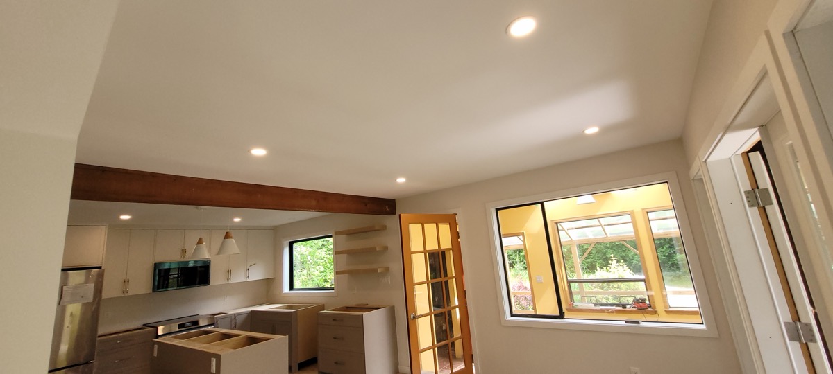 New pot lights and an exposed beam in an open-plan kitchen renovation.