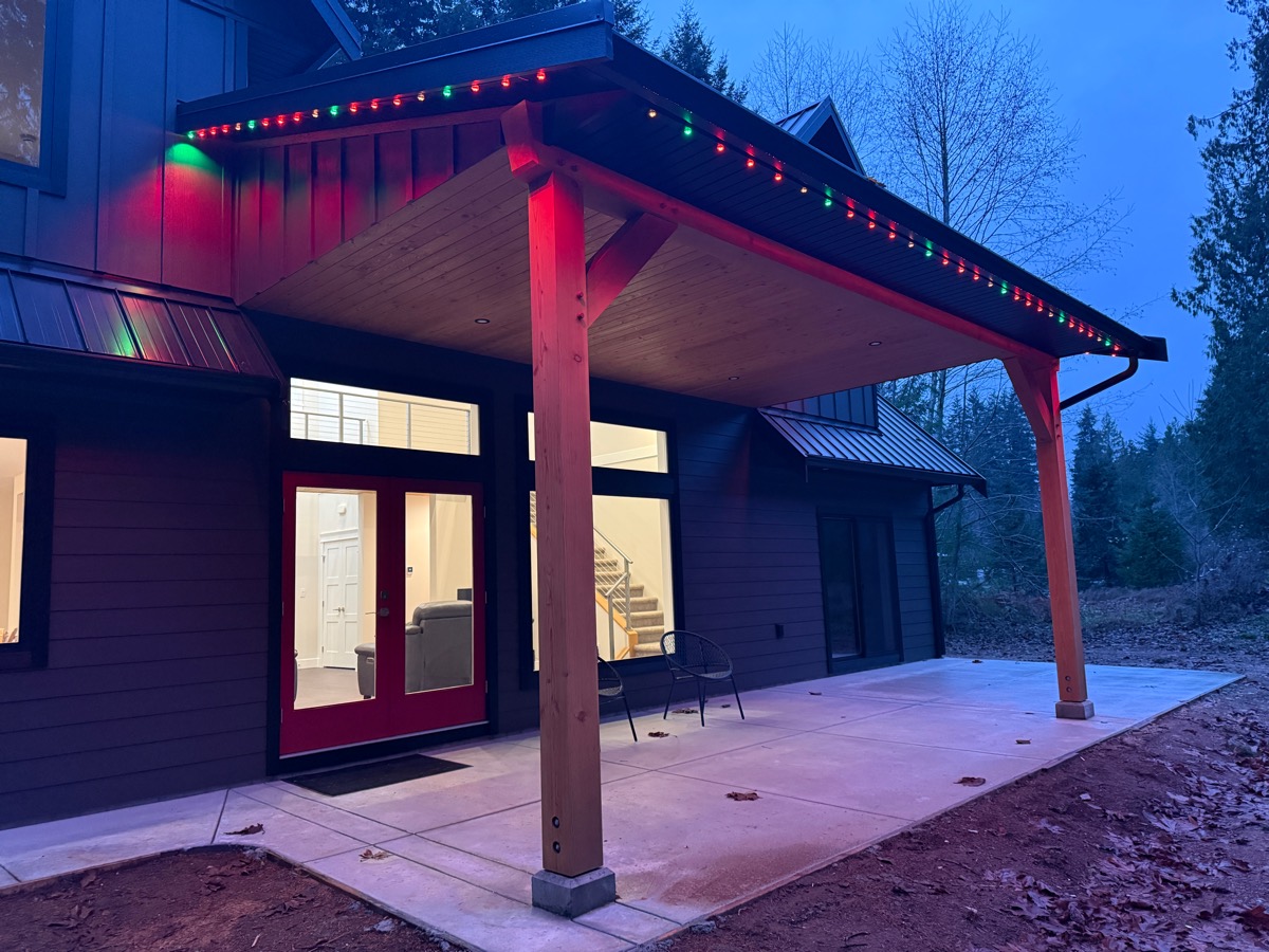 Red and green Gemstone Lights along a covered patio eave on a modern home.