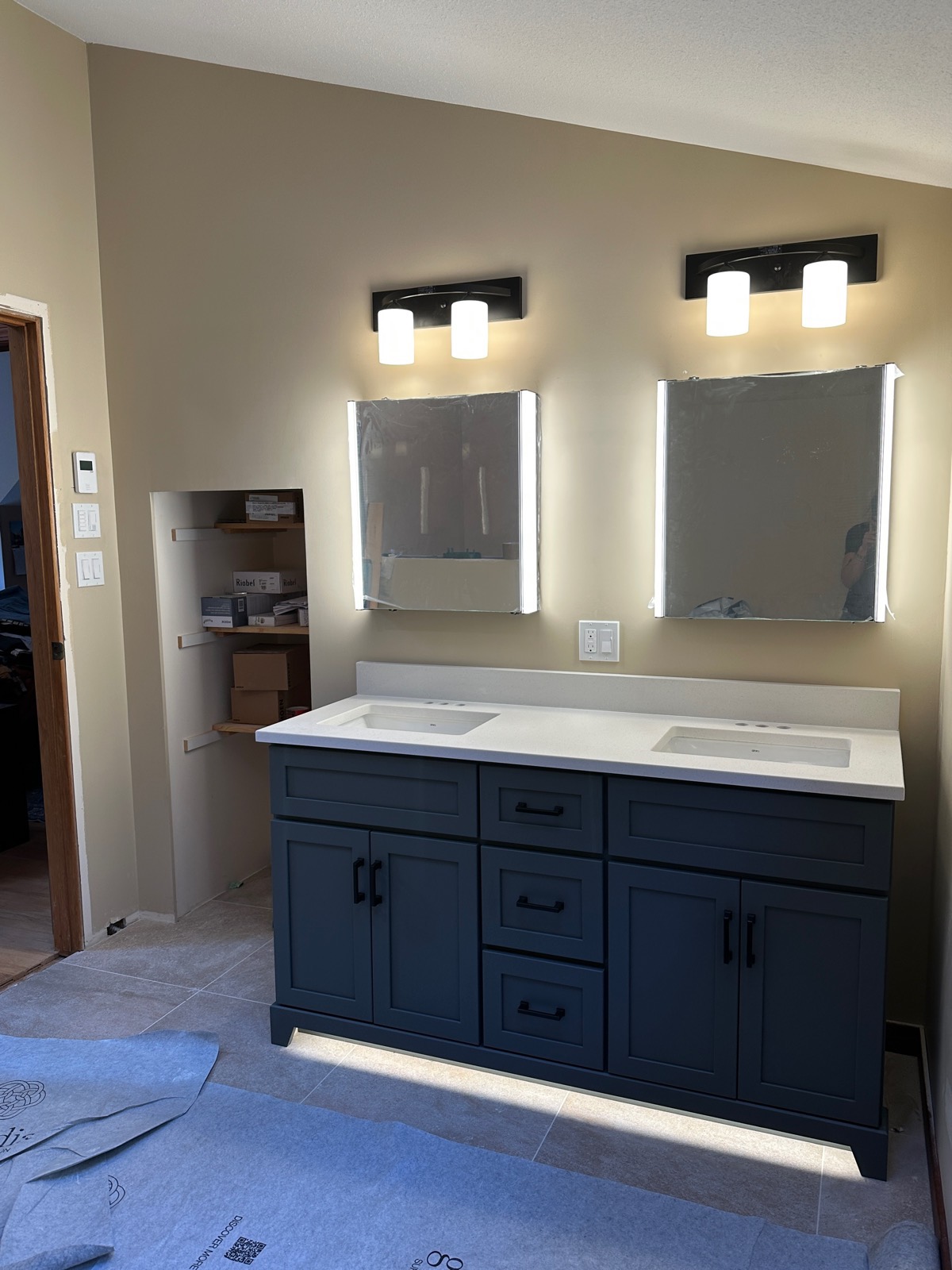 Vanity lights and under-cabinet lighting on a navy double vanity.